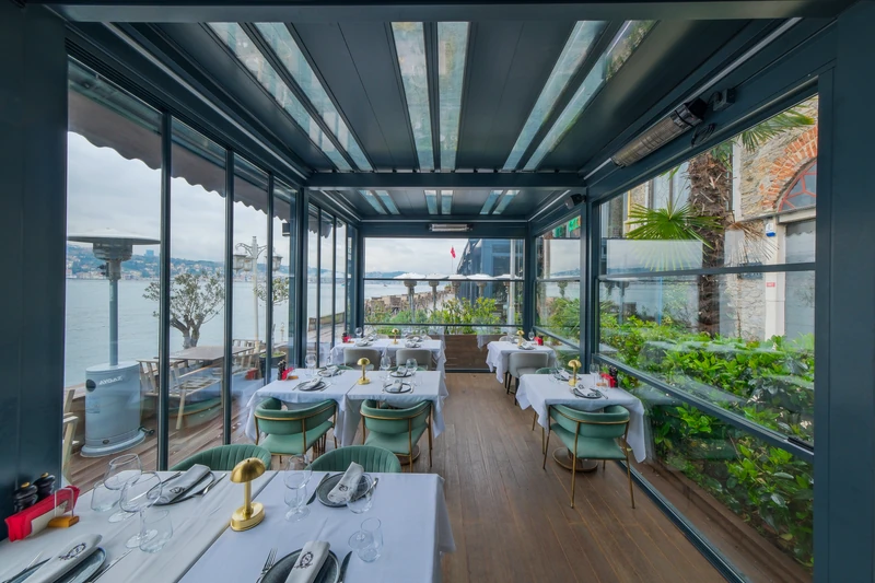 Commercial outdoor dining area enclosed with glass beneath a Royal pergola.