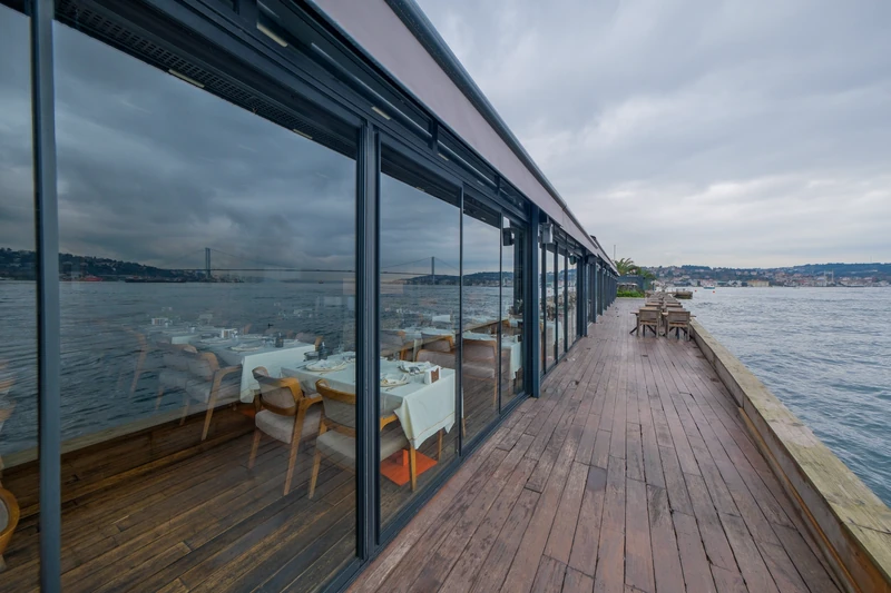 Railglass panels enclosing a waterfront commercial terrace.