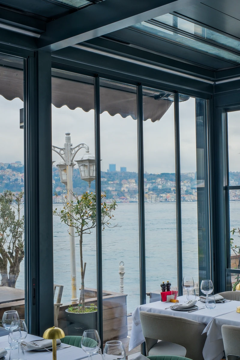 Tall Railglass panels preserving waterfront views from a restaurant interior.