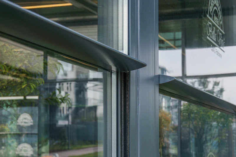 Close detail of Upglass aluminum framing and vertically moving glass panels.