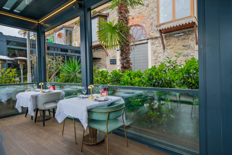 Open Upglass enclosure surrounding a restaurant dining terrace.
