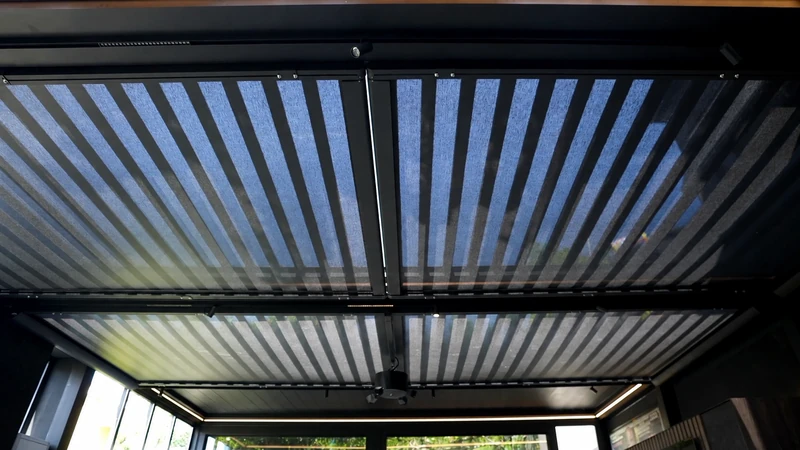 Shading system integrated beneath an architectural pergola roof.