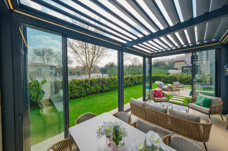 Residential lounge beneath an open bioclimatic pergola roof.