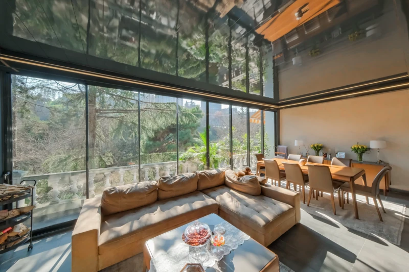 Enclosed residential living space with Railglass and unobstructed garden views.
