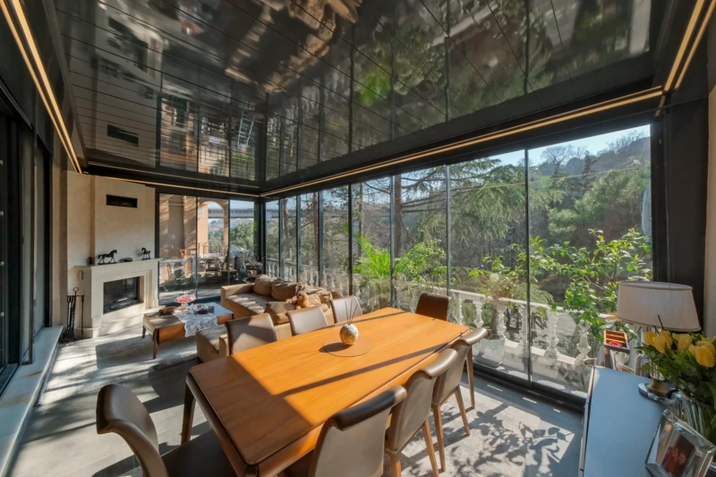 Royal pergola with a closed roof above a sunlit dining and living space.