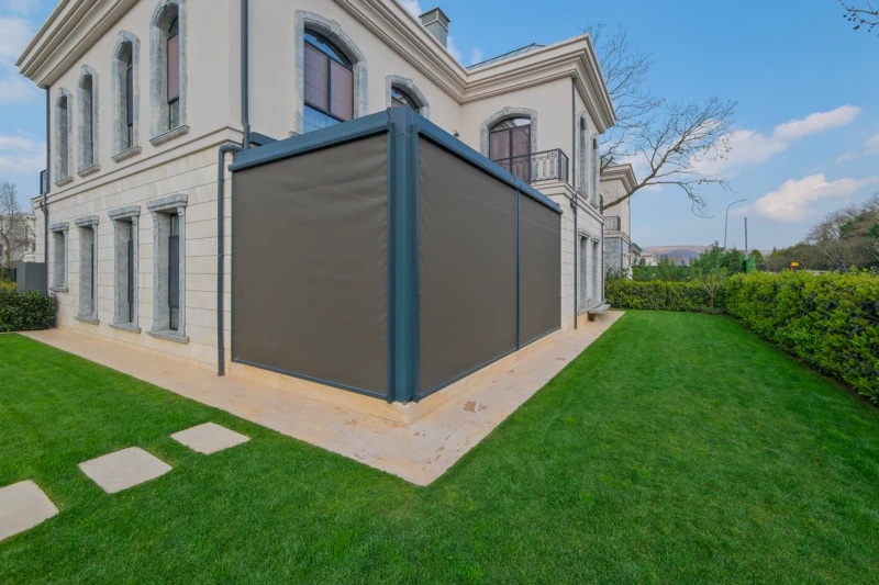 Motorized exterior shading around a pergola beside a home.